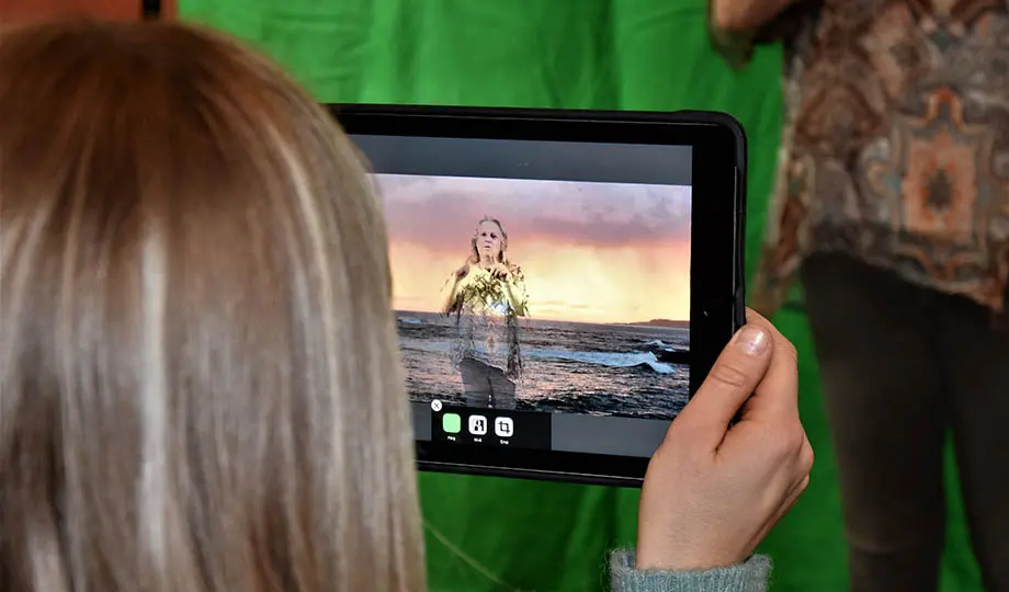 kvinna håller lärplatta, filmar kvinna mittemot med bakgrundseffekter